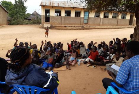 P.3 children waving at AAU staff during a monitoring visit 
