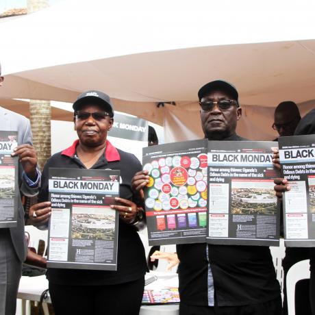 ActionAid uganda country director Xavier Ejoyi ,Rev Father Gaetano Batanyenda and former ethics minister Dr Miria Matembe pose with copies of the Black monday Newsletter during the relaunch 