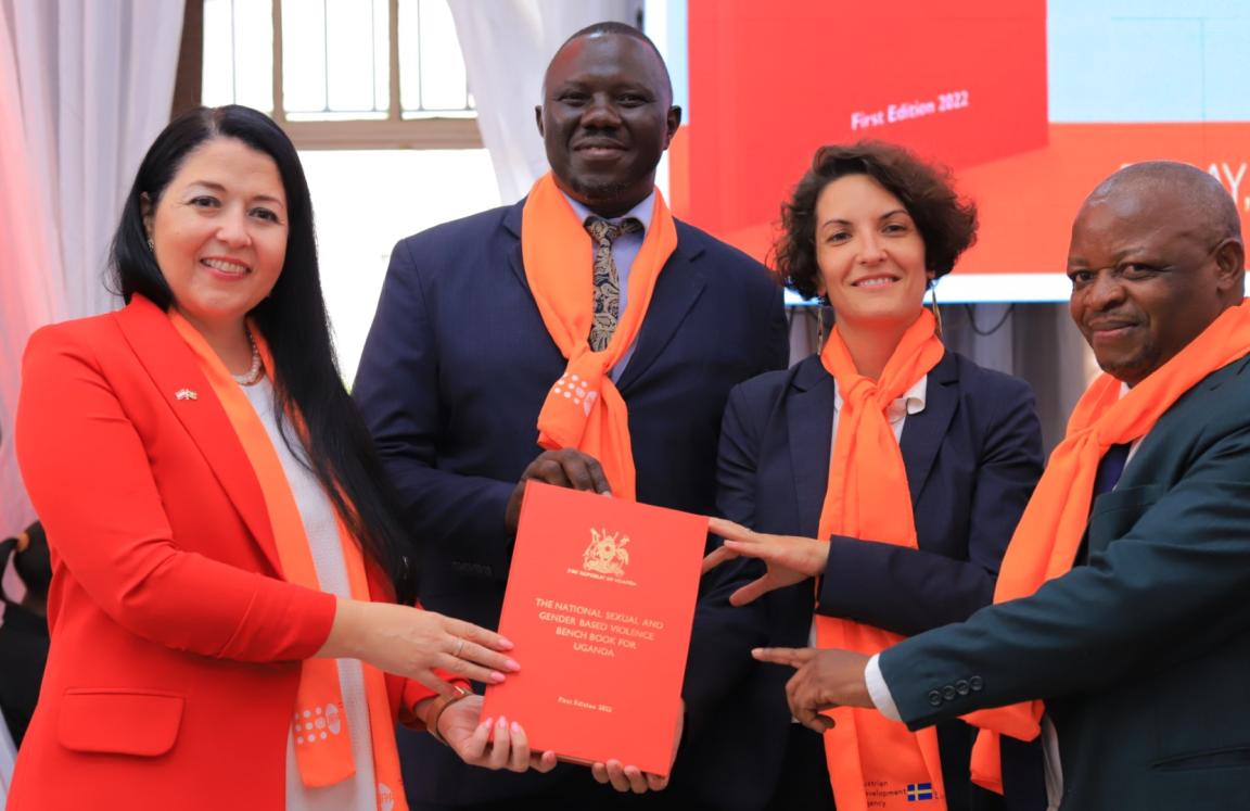 ActionAid International Country Director, Xavier Ejoyi, Dr Katja of Australian Development Agency, Laura of UNFPA, and Justice Batema take a photo with the Sexual and Gender Based Violence Bench Book at High Court.