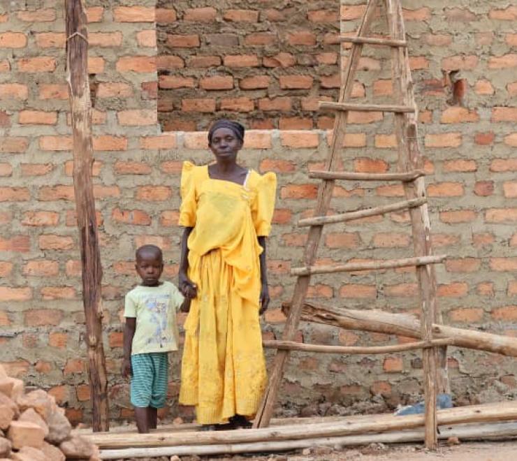 Imelda and her grandson outside her house under construction