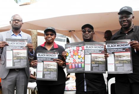 ActionAid uganda country director Xavier Ejoyi ,Rev Father Gaetano Batanyenda and former ethics minister Dr Miria Matembe pose with copies of the Black monday Newsletter during the relaunch 