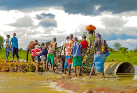 Residents in Katakwi attempt to cross a a flooded road.