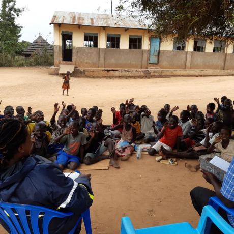 P.3 children waving at AAU staff during a monitoring visit 