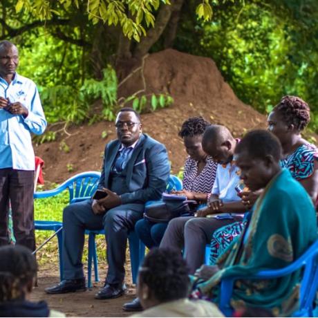 A photo of James Okot(standing) a war survivor narrating his journey of access to land Justice through court