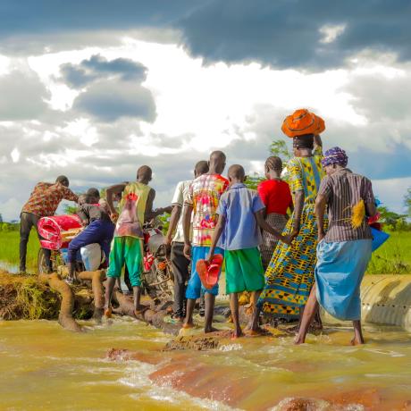 Residents in Katakwi attempt to cross a a flooded road.