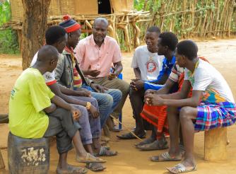 Emmanuel Ochieng, a legal officer with ActionAid International, speaks to a team of Male Action Group members