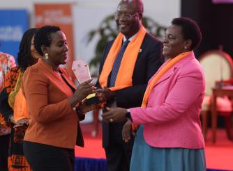 Angel Akoth, the GBV Coordinator at ActionAid International receives her award from Hon. Peace Mutuzo