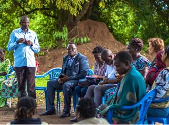 A photo of James Okot(standing) a war survivor narrating his journey of access to land Justice through court