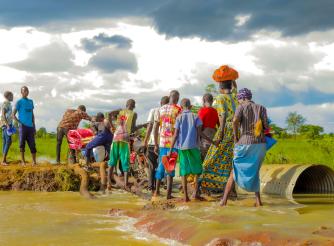 Residents in Katakwi attempt to cross a a flooded road.